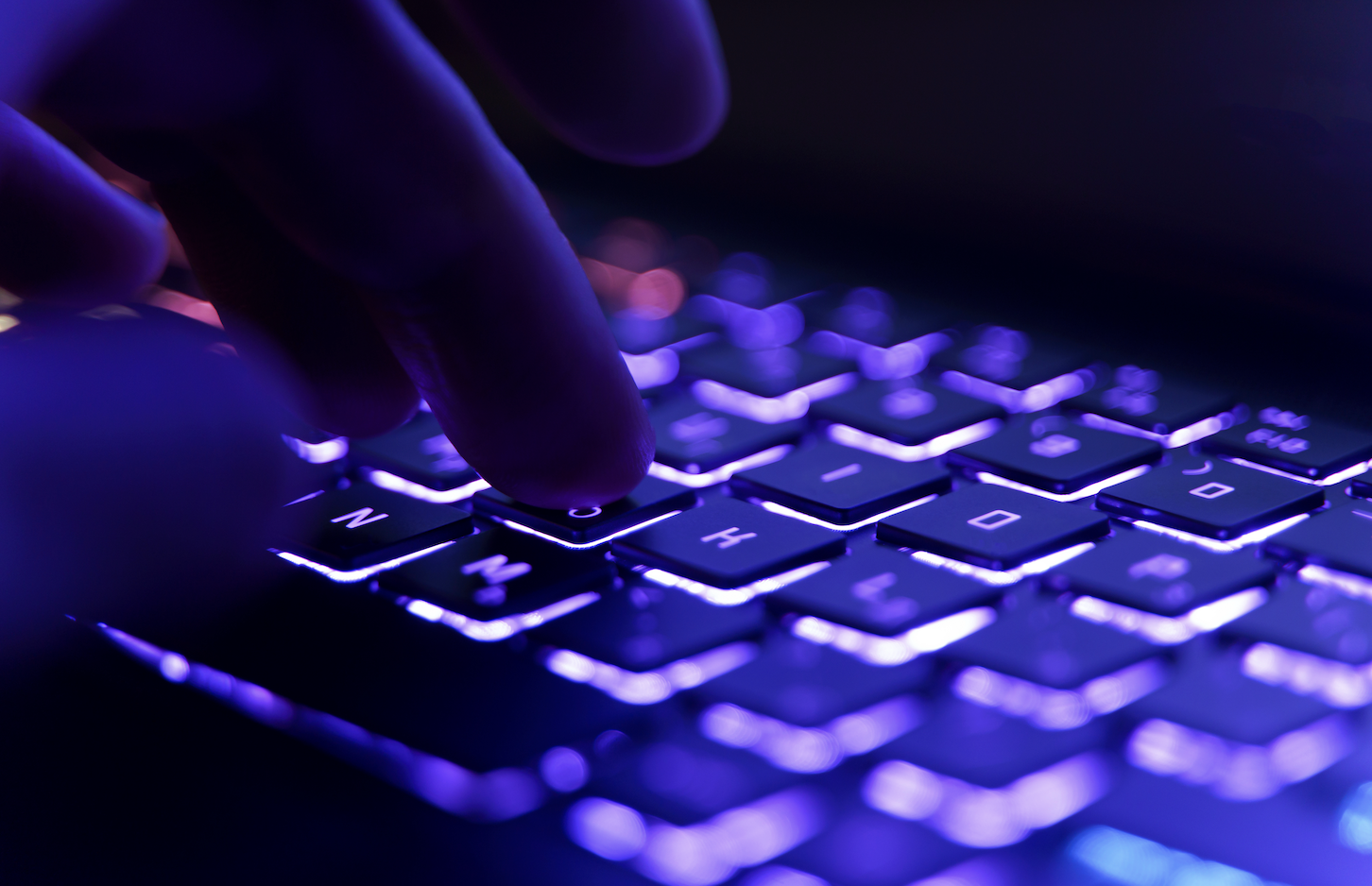 A laptop keyboard with blue backlighting.