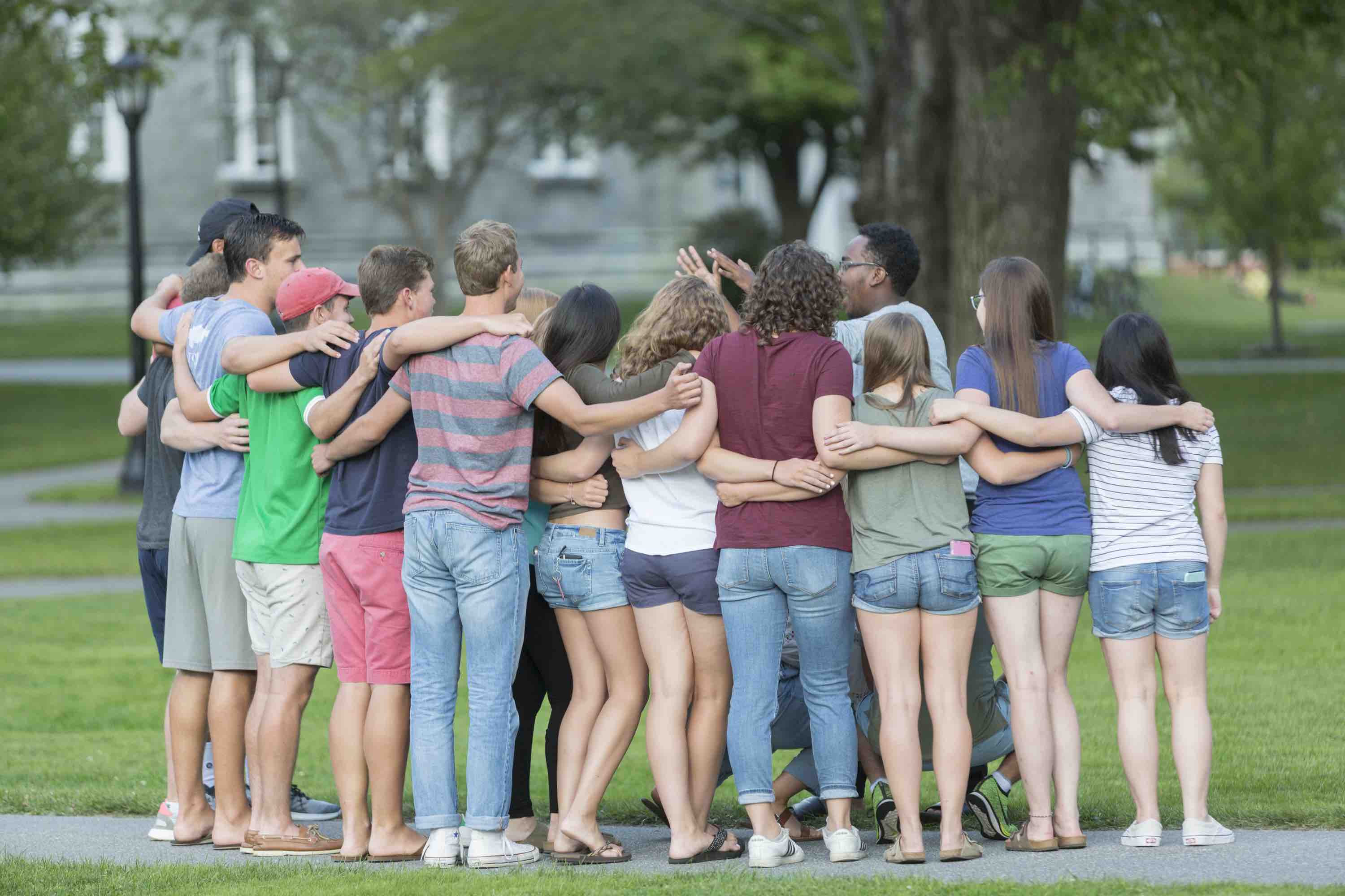 Students gathered around a student leader listening to him talk