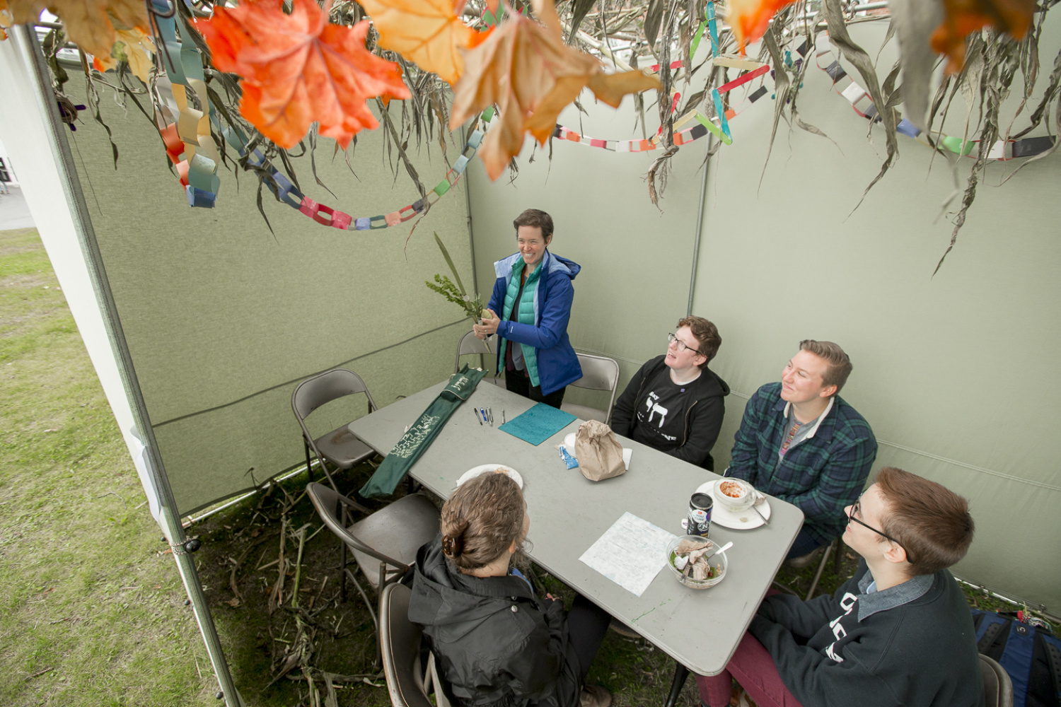 Students sit in the Sukka with Rabbi and observe the Jewish holiday Sukkot