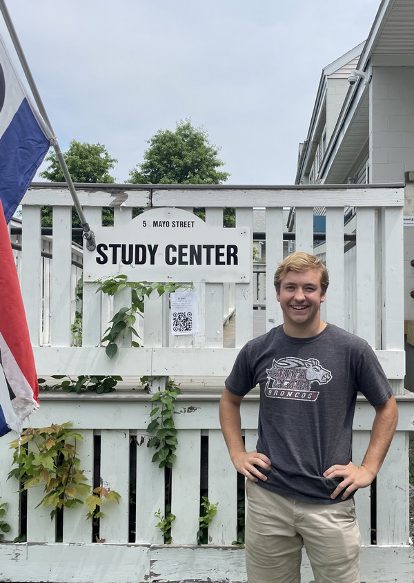 Alex stands in front of a sign that reads 'Study Center'. 
