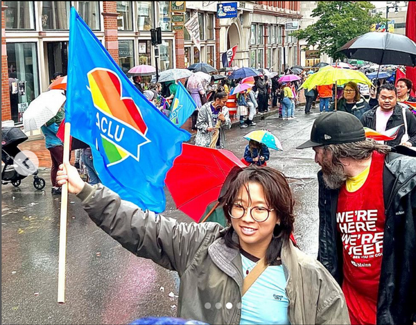 Carina holds a flag at a parade.