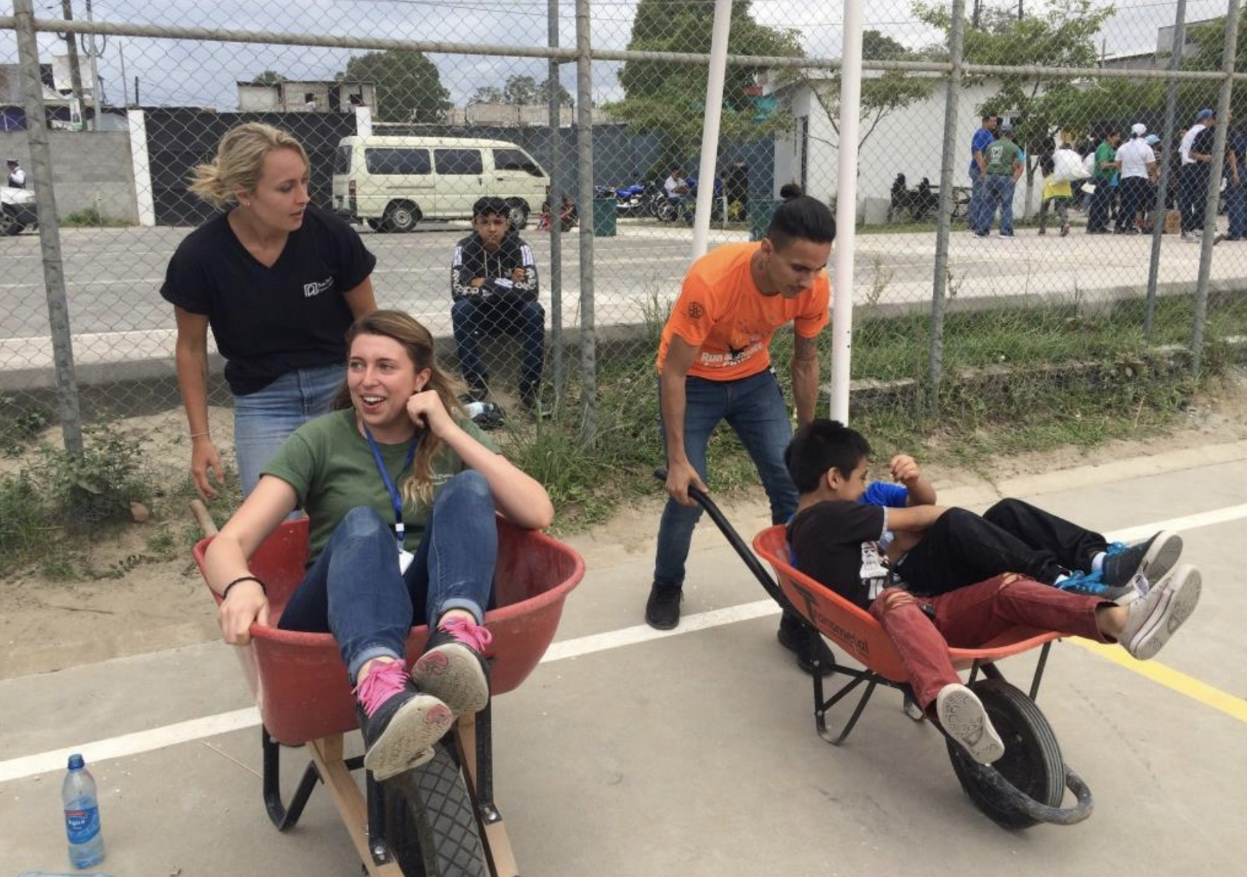 Young people playing with wheelbarrows.