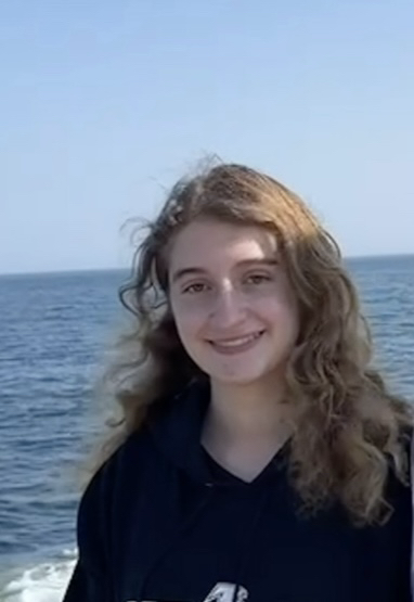 Margaret smiles. Ocean background. 