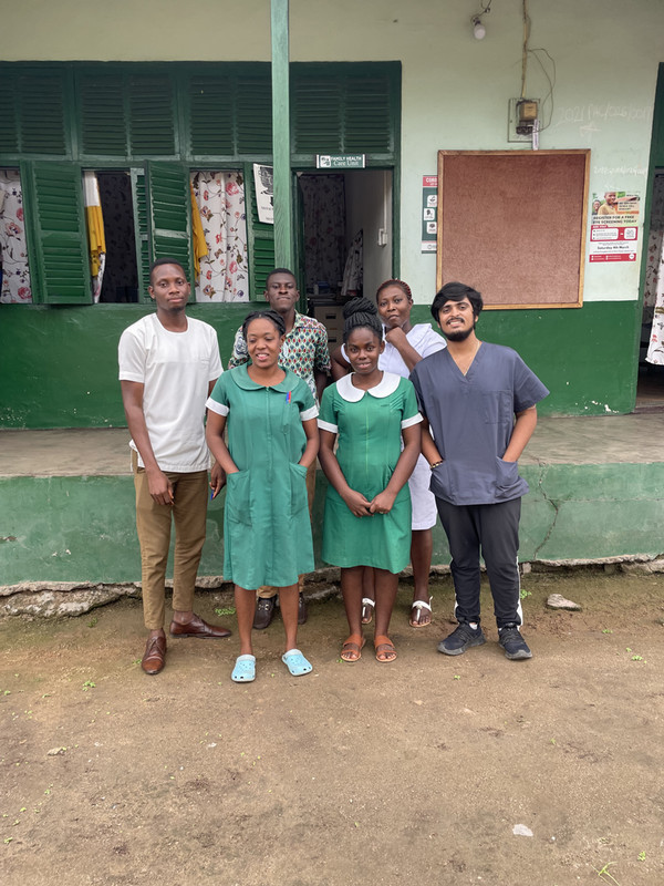 Pranav stands on a street outside a building with five other people.