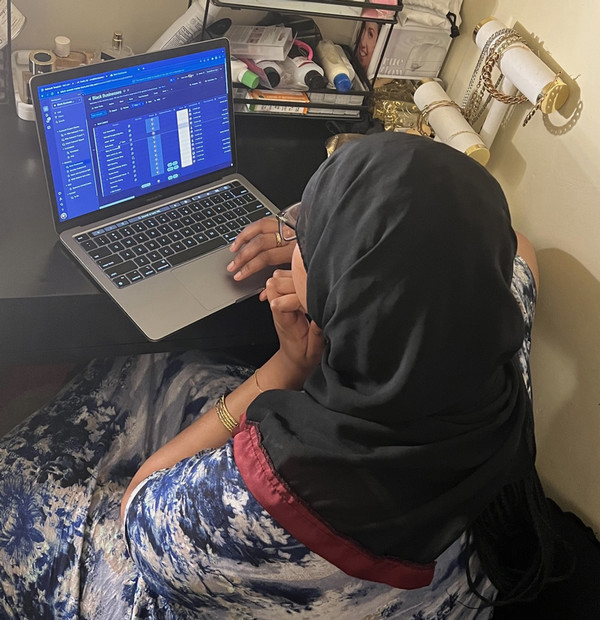 Uma sits working at a computer.