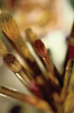 Paint brushes sit in a jar