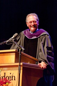 Mills stands at podium and smiles at the camera