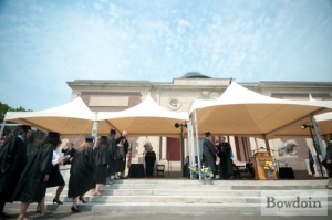 People in black robes walk the steps to the art museum