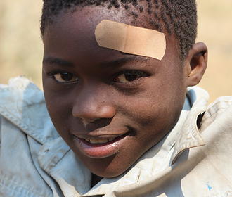 Smiling Zambian child with bandaid 