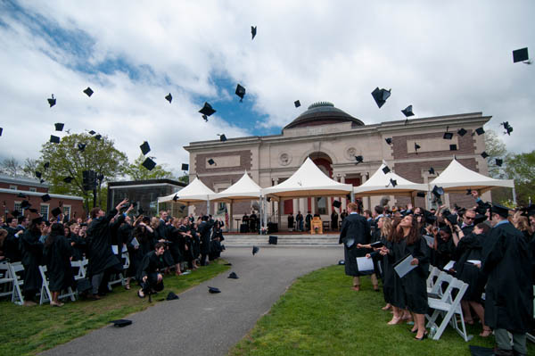 Graduating seniors toss mortar boards in the air.