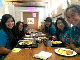 Students with food sitting at table smiling