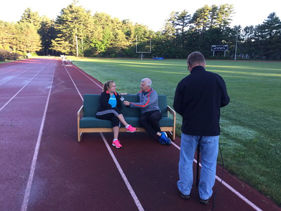 Kristin Steinman and Lee Nelson sitting on couch located on a track field
