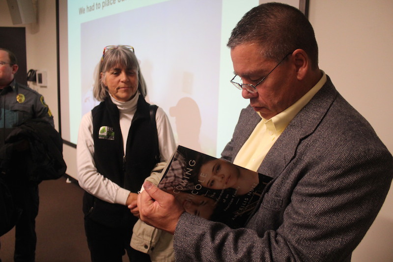 Wayne Maines autographs a copy of Becoming Nicole