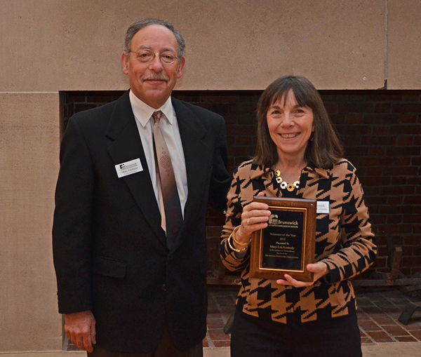 Bowdoin Dining Director Mary Lou Kennedy receives the Brunswick Downtown Association Volunteer of the Year Award from Mike Feldman, chair of the BDA Board of Directors.