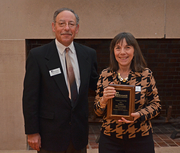 Bowdoin Dining Director Mary Lou Kennedy receives the Brunswick Downtown Association Volunteer of the Year Award from Mike Feldman, chair of the BDA Board of Directors.