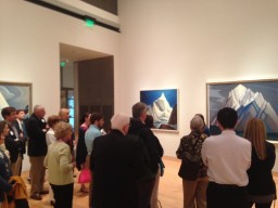 Crowd looking at paintings on wall