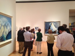 Crowd looking at paintings on wall