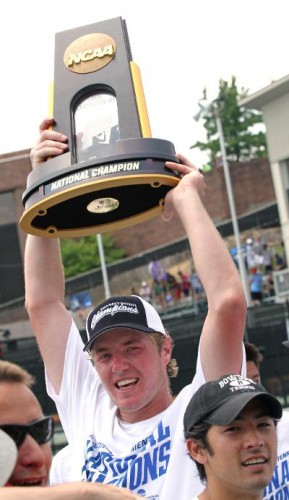 Student tennis player holds the NCAA trophy