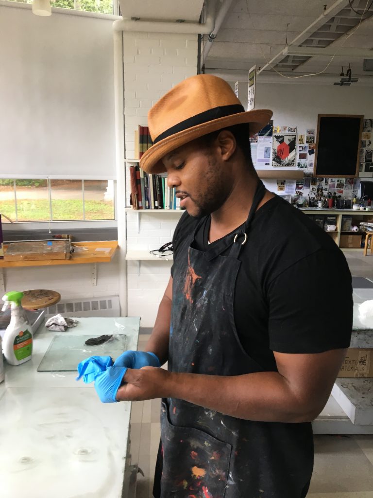 artist in working smock stand at counter