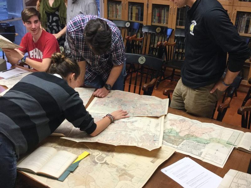 Students with the class Maps, Territory, and Power, checking out Special Collections maps