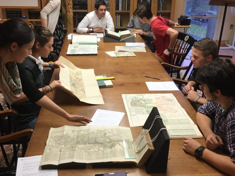Students with the class Maps, Territory, and Power, checking out Special Collections maps
