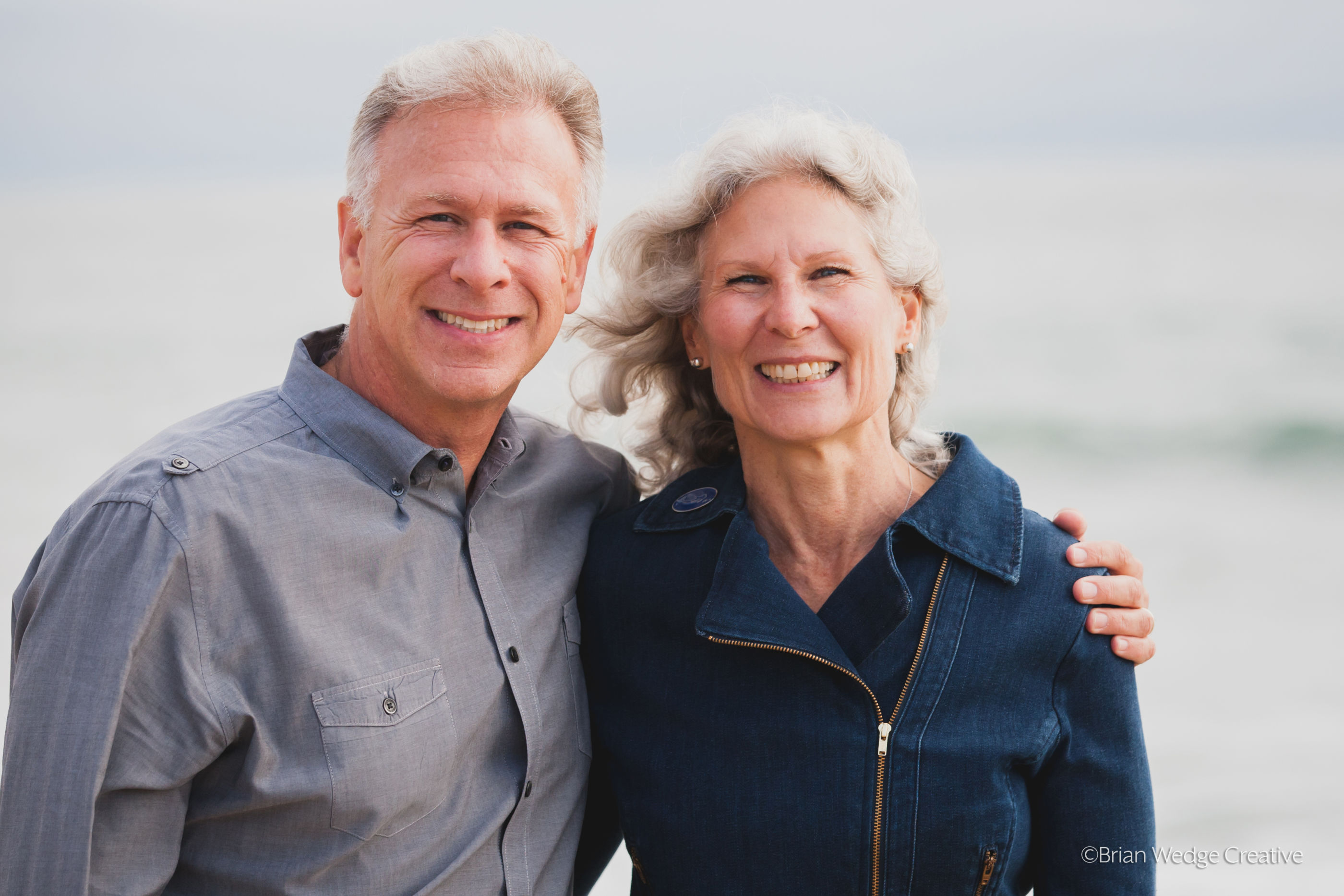 The Schillers stand on the Maine coast