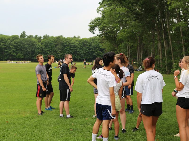 Light and dark teams assemble on the field.