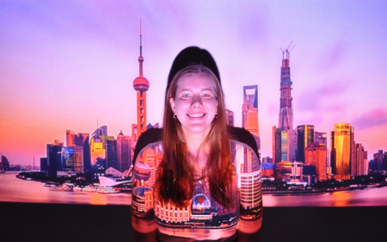 Student appears agaings Shanghai photo backdrop