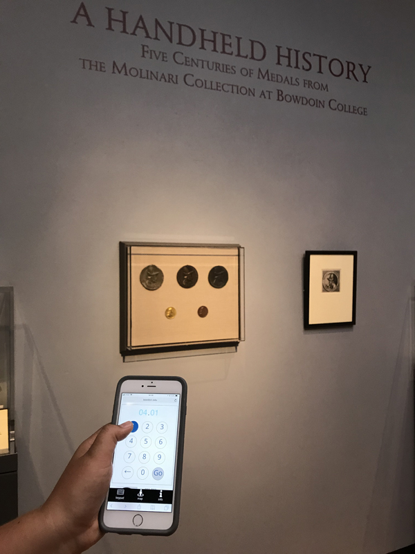 A visitor uses their handheld device in the exhibition