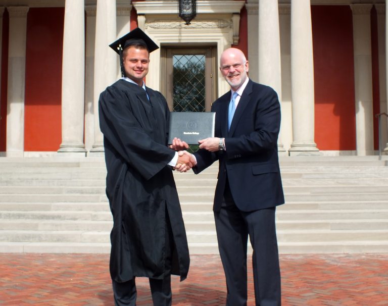 John Pietro ’18 gets his diploma and handshake from President Clayton Rose