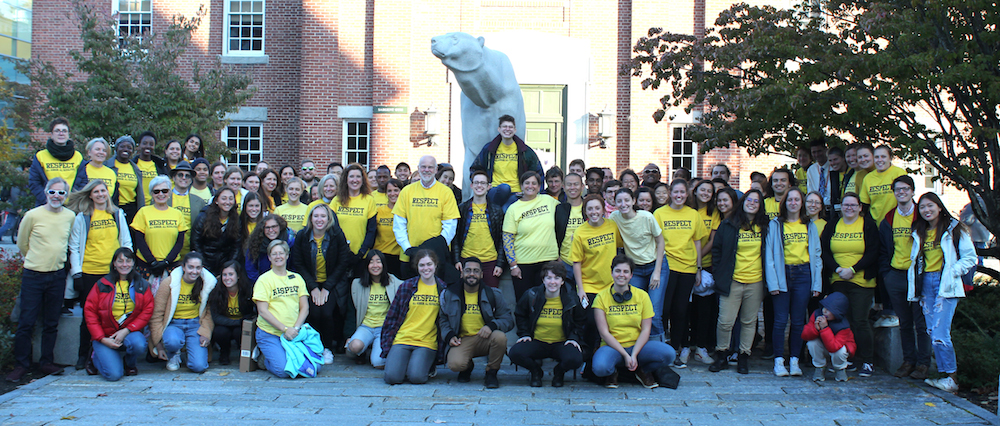 A crowd gathered in front of the polar bear wearing their yellow shirts