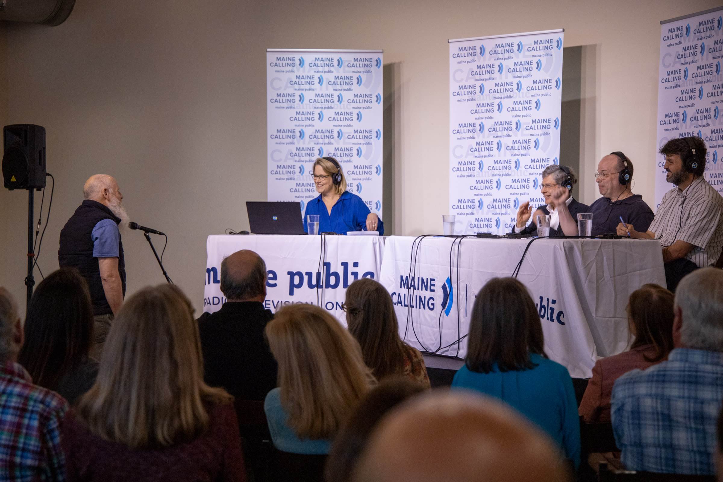 An audience member asks a question before the panel comprising Steve Marjercik, Eric Chown, and Fernando Nascimento