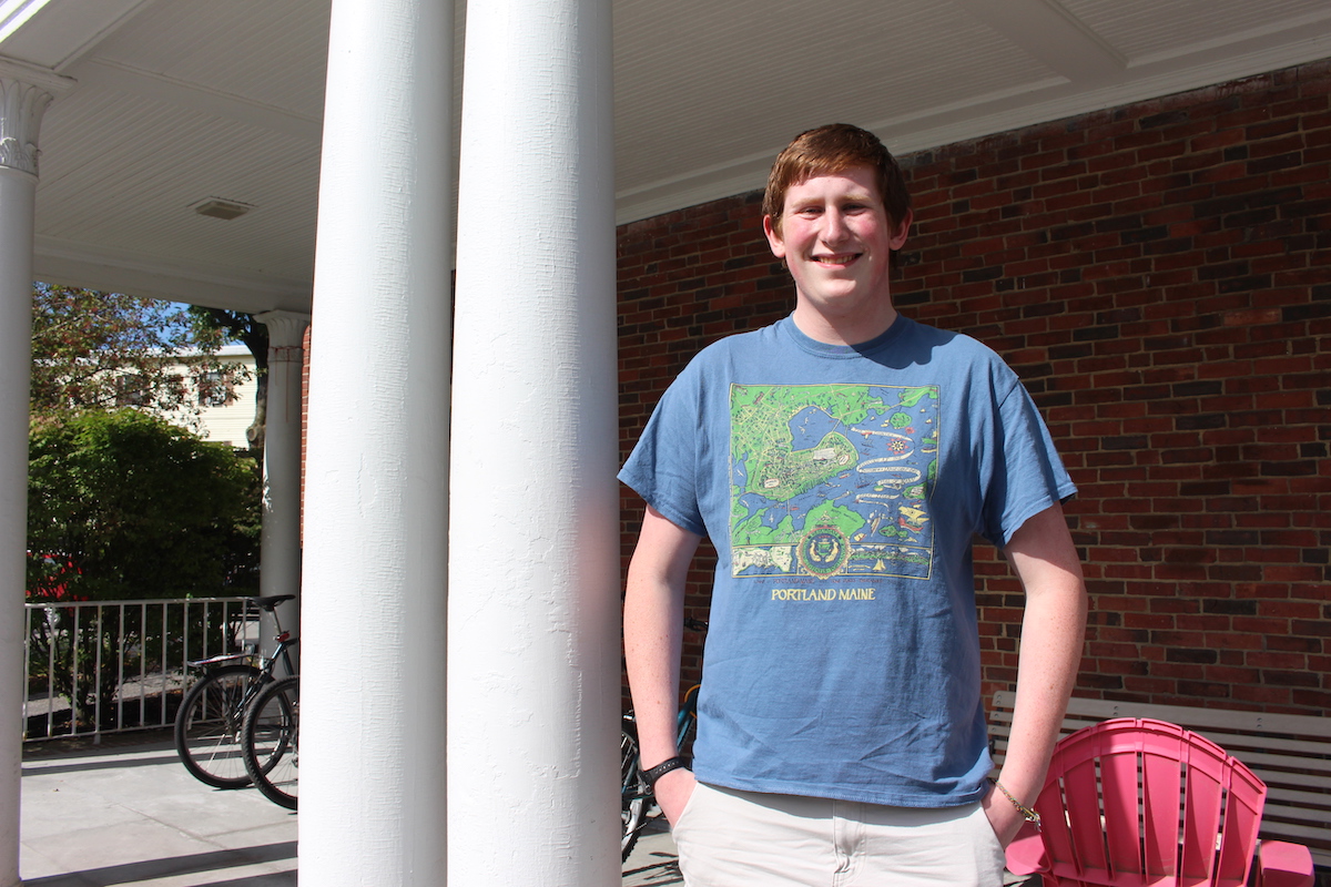 Alex Gates stands on the porch of Howell House