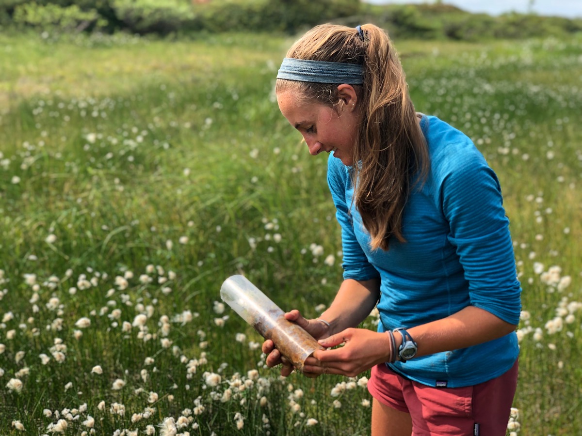 Anneka Williams doing research in the Arctic tundra, holding a sample