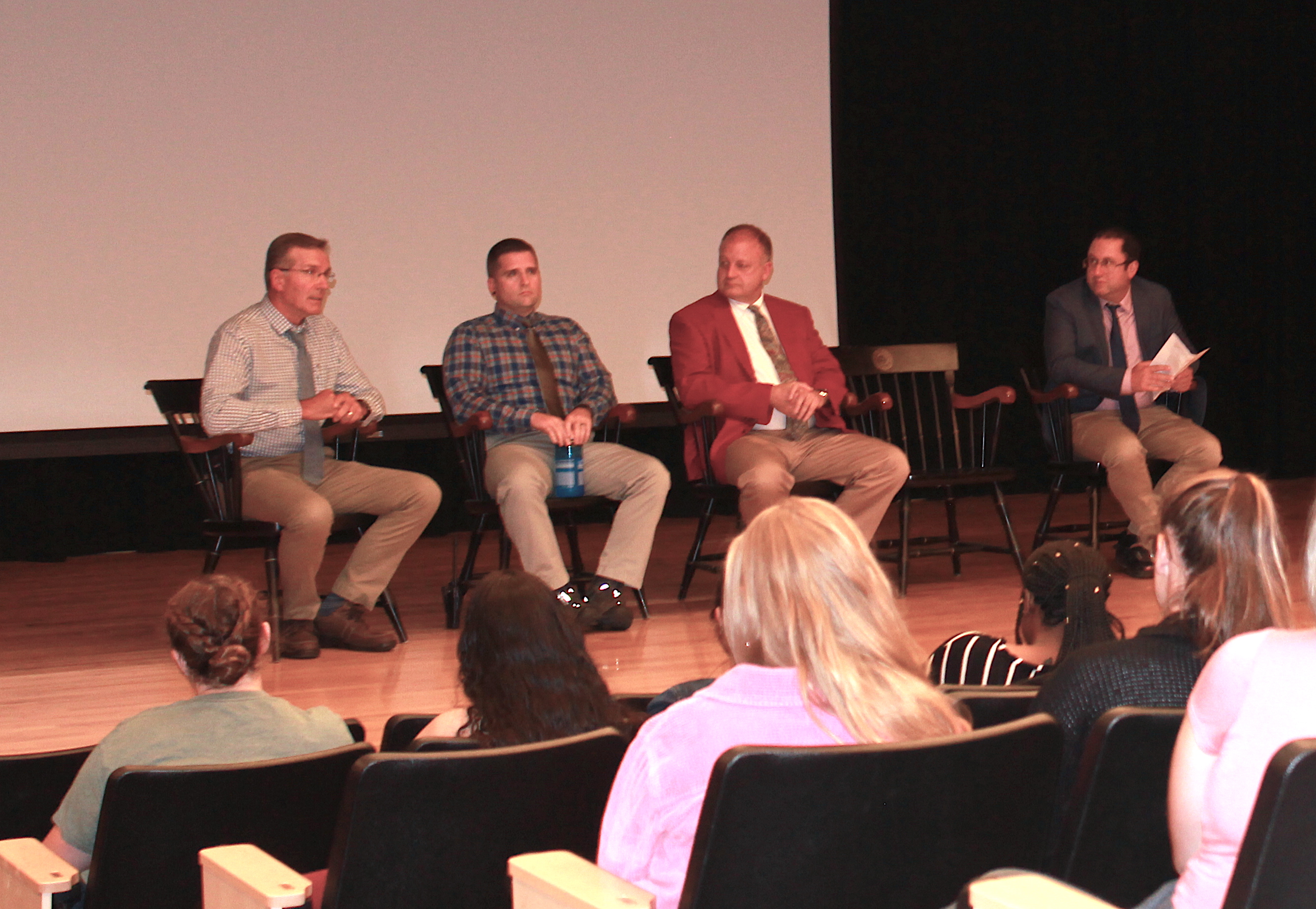 Bowdoin security leaders and a Brunswick police officer sit on stage