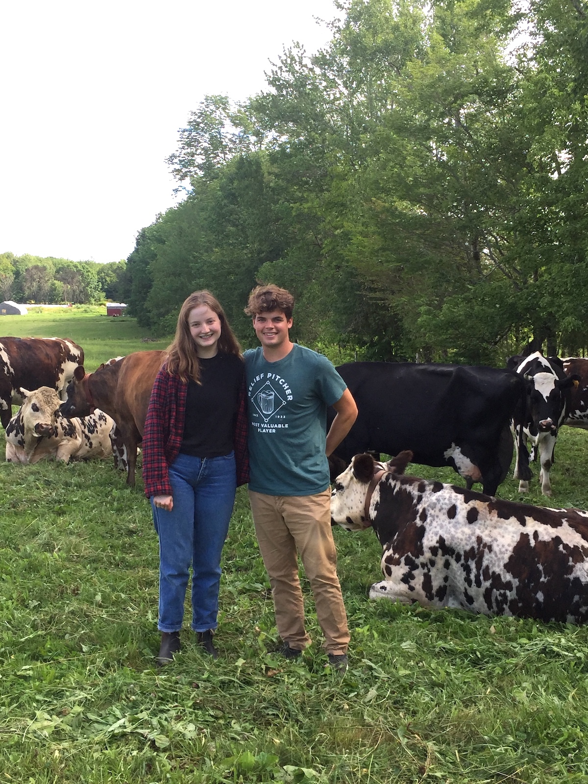 Eleanor Paasche and Cal Soule in a meadow of dairy cows