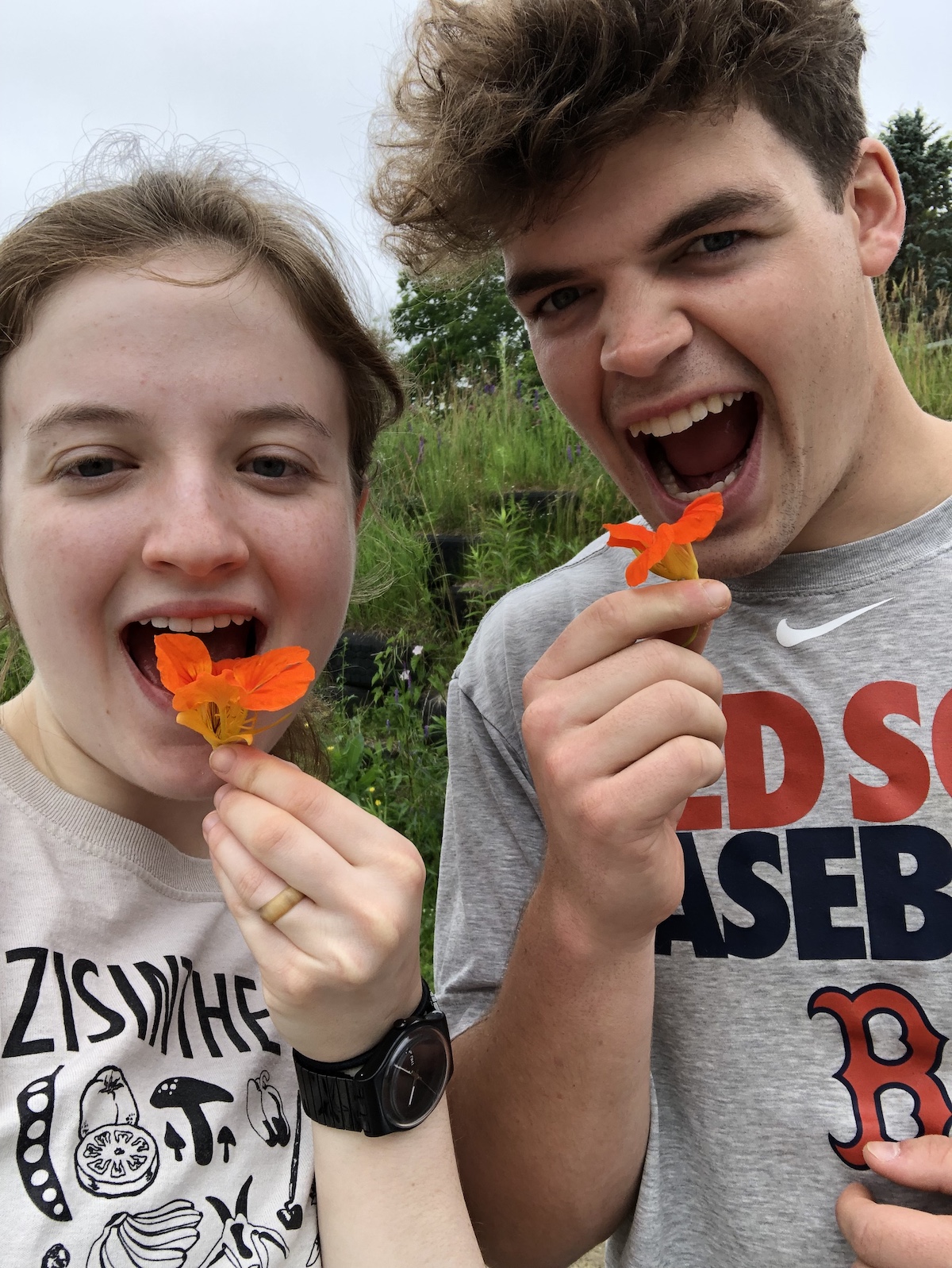 Eleanor and Cal pretending to eat orange flowers
