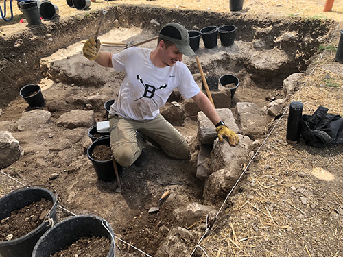 Cole Crawford at an excavation site in Israel uncovering ruins.