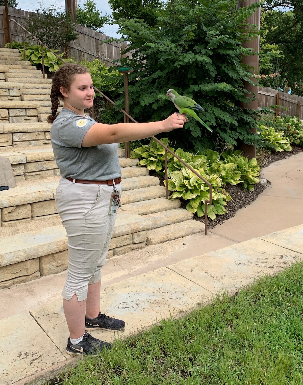 Emilia Lawler stands with a parrot