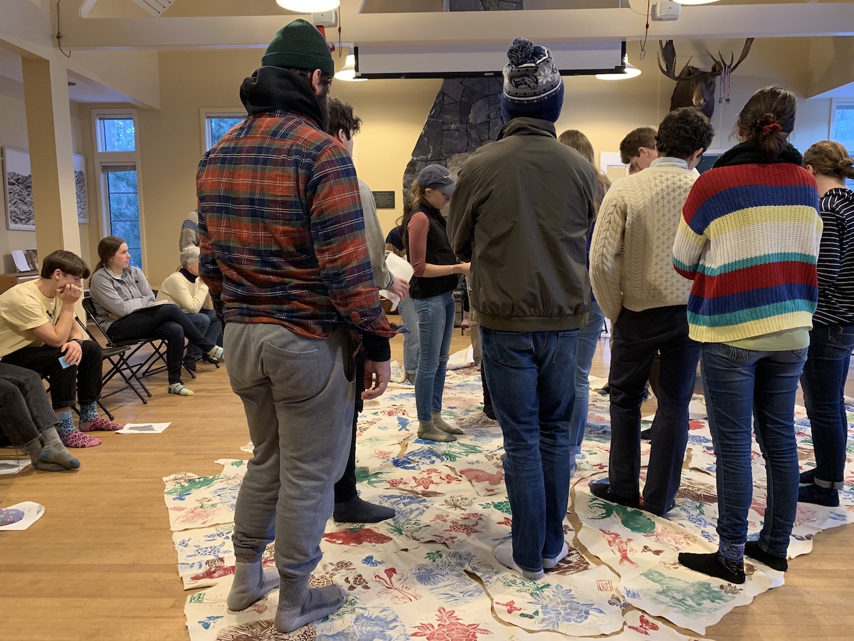 Students stand on cloth map of Maine
