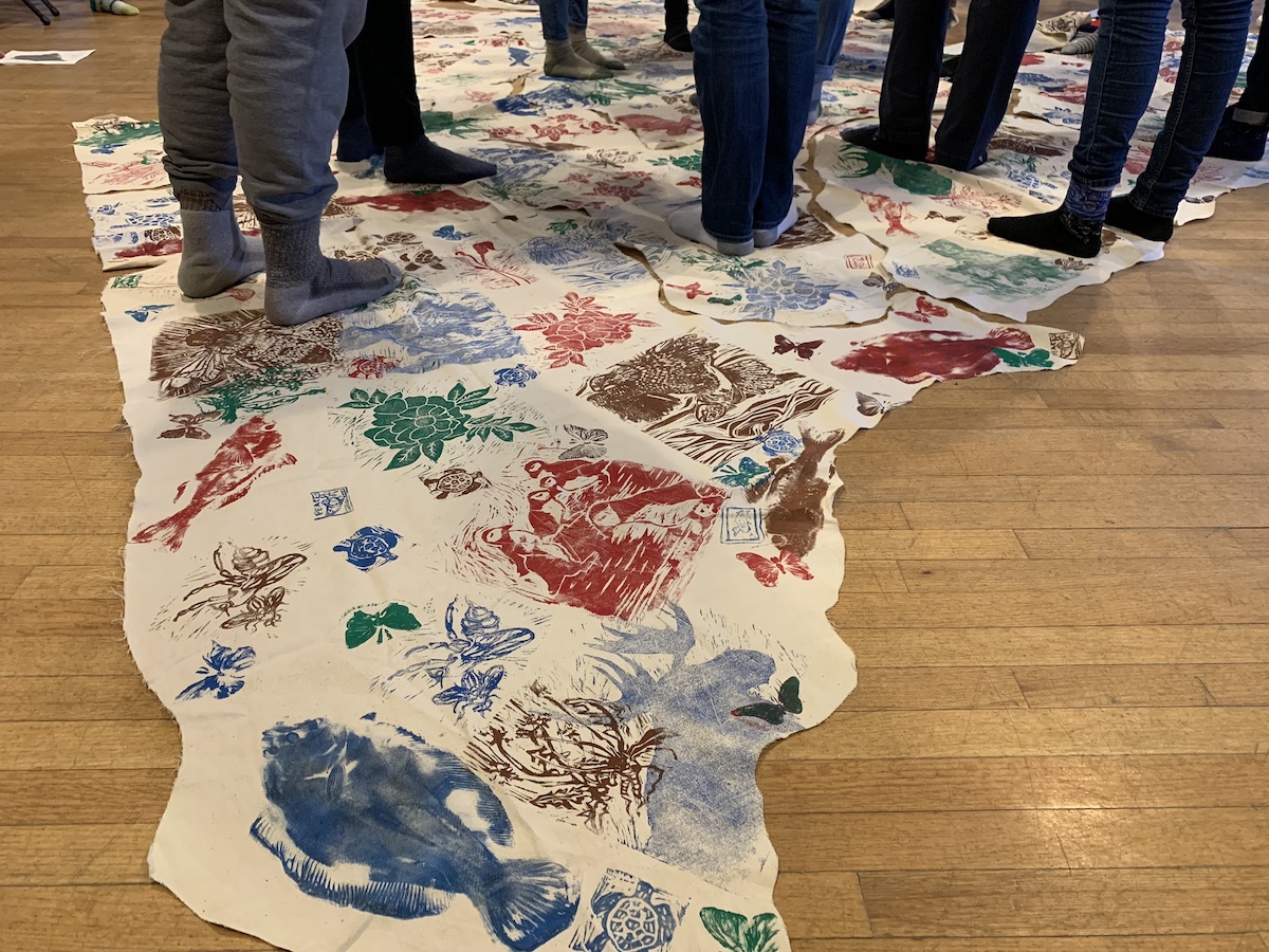Students stand on cloth map of Maine