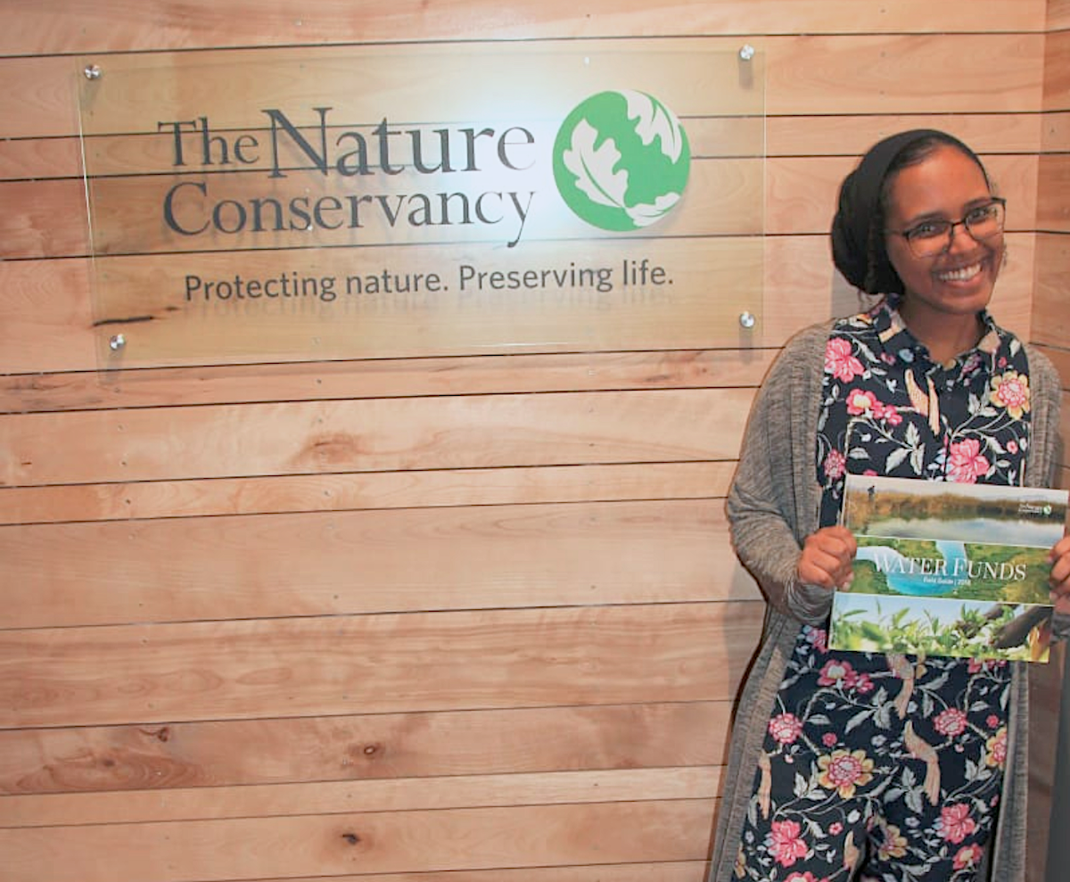 Samara standing in front of a Nature Conservancy sign