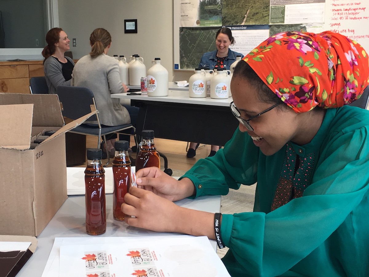 Samara Nassor bottling maple syrup jugs