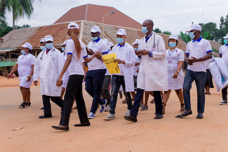 Health care workers walk through the village to raise awarness about Covid-19