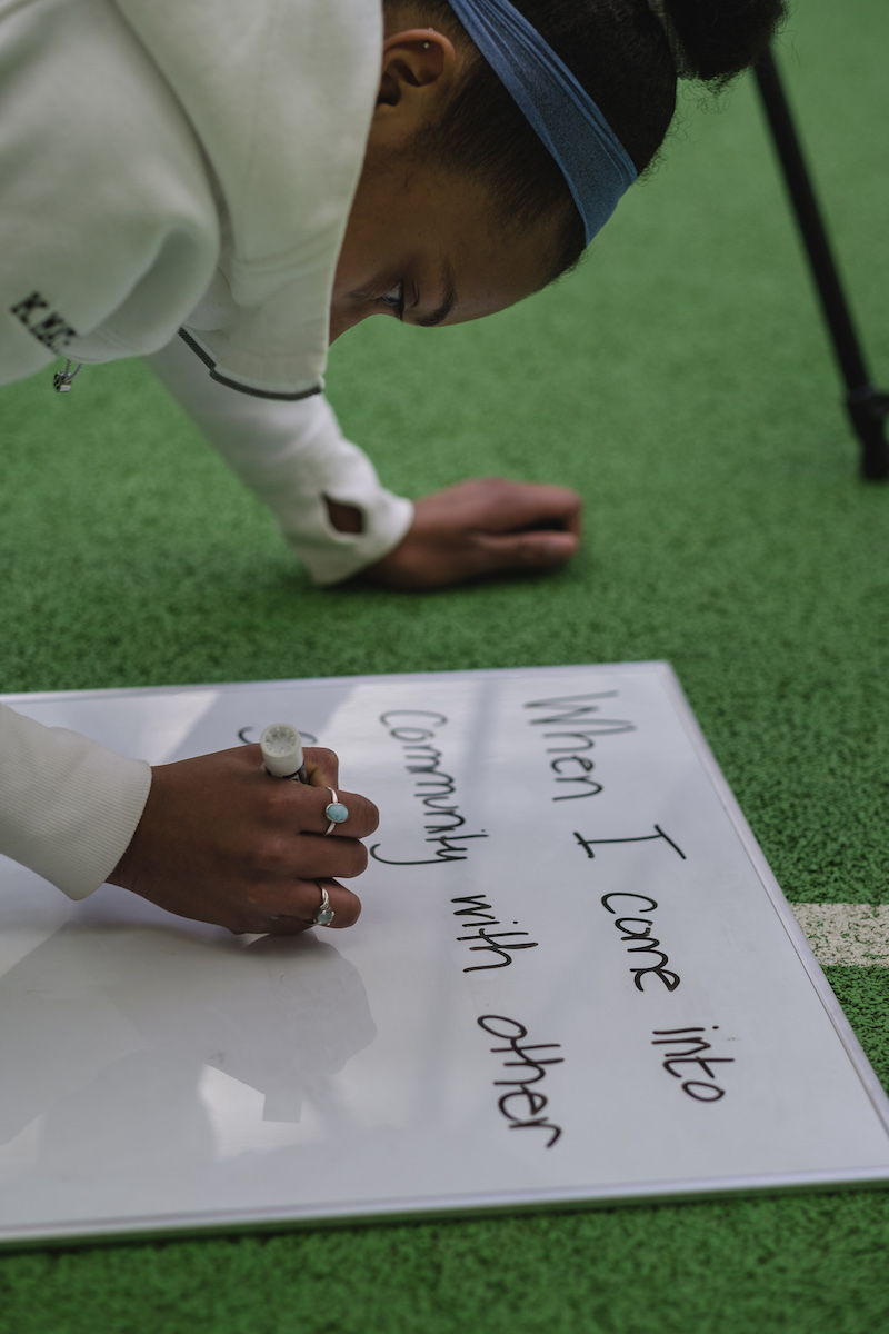 Student writes her answers on the whiteboard