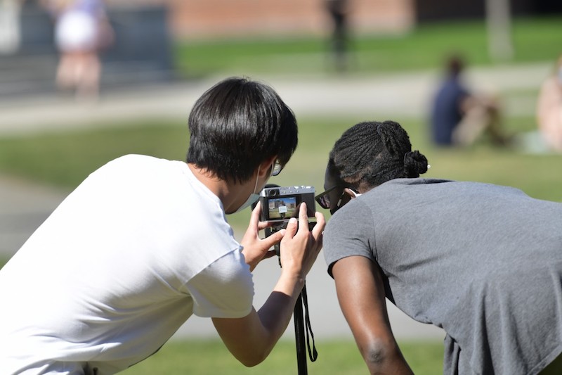 Cheng Xing checks out photos with Ayana Opong-Nyantekyi ’23