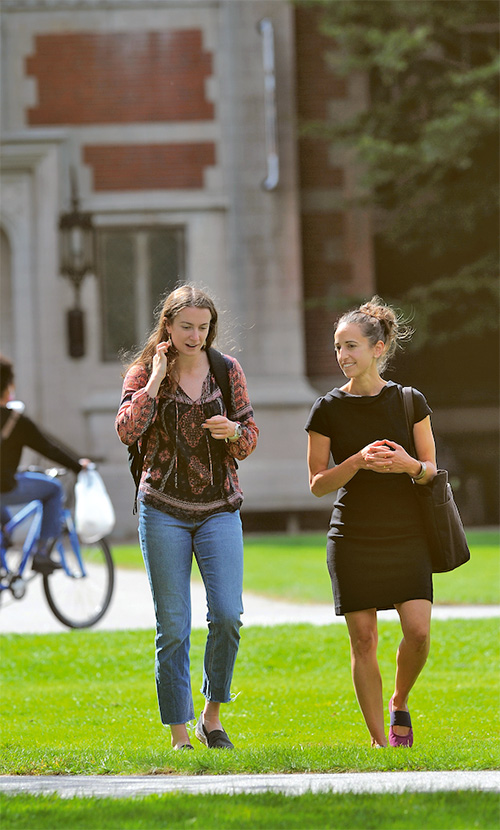 Elias walks on the Bowdoin quad with a student.