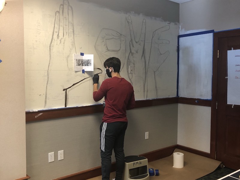 Mo Kilani working on his mural