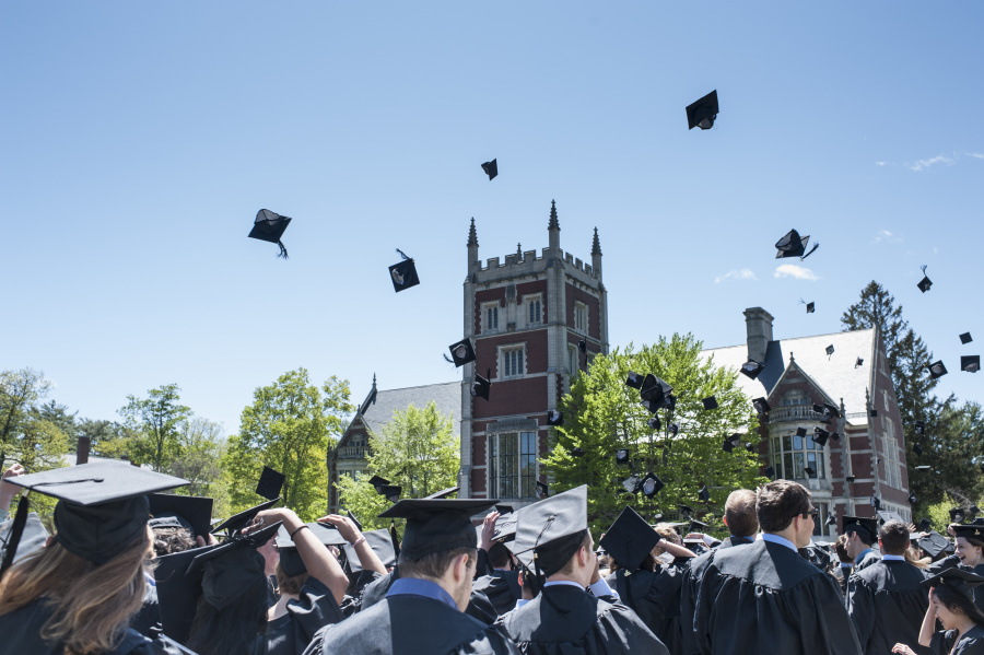 New graduates throwing mortarboards into the air.