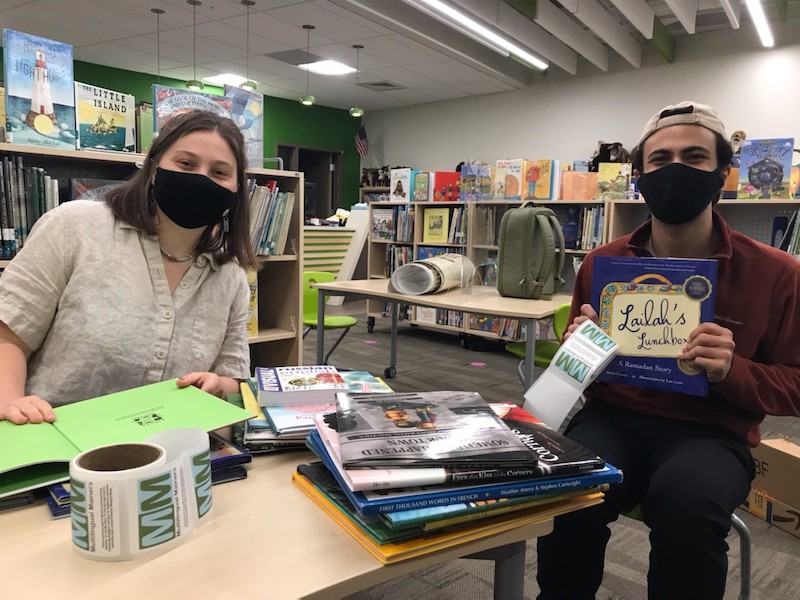 Multilingual Mainers seniors show off the picture books they acquired for the local school's library